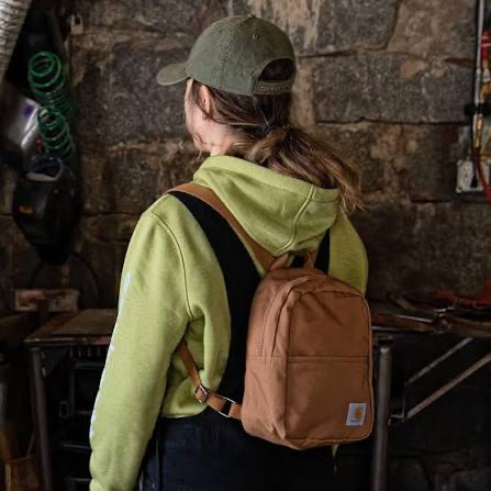Student wearing a Carhartt canvas backpack in a workshop setting